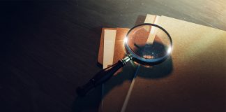 Une loupe et des dossiers sur une table