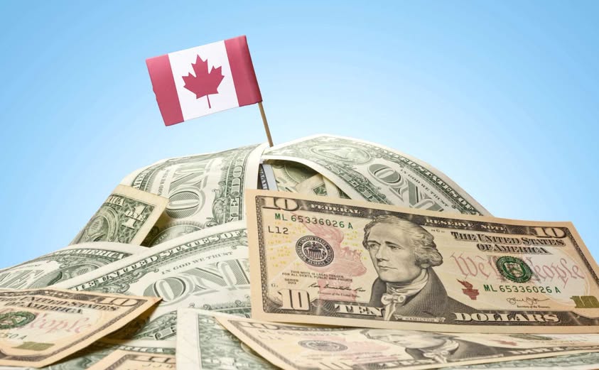Dollars canadiens et américains devant un drapeau du Canada
